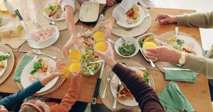Lunch, cheers and family with juice in dining room for health, wellness and nutrition meal. Toast, celebrate and top view closeup of people with fruit beverage at a brunch or breakfast event at home.
