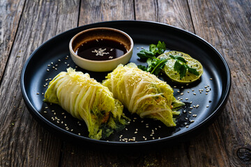Stuffed Asian cabbage rolls and soy sauce on wooden background