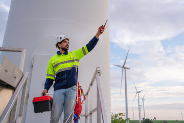 Engineer wearing uniform hold equipment box inspection work in wind turbine farms rotation to...