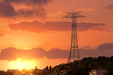 A large power line support on a mountain against a background of a beautiful sunset sky.
