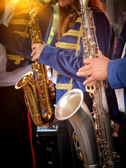  Vertical close-up images of a group of saxophonists in the foreground.