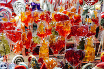 Sweet red orange lollipops cockerel figurines at Christmas market © asauriet