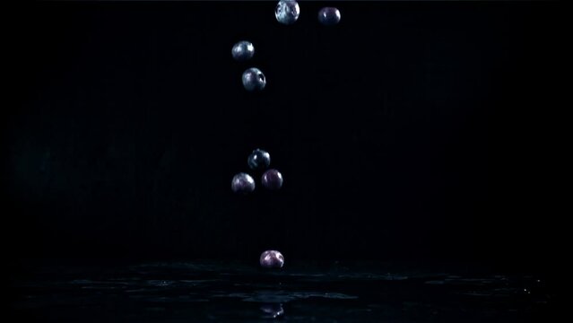 Blueberries fall on a black table. Filmed on a high-speed camera at 1000 fps. High quality FullHD footage