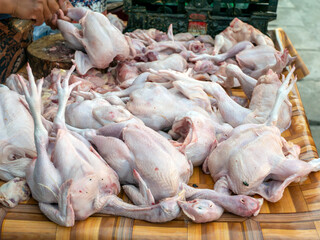 Raw chickens and flies on a plastic carpet, in a traditional market, in Yogyakarta, Indonesia