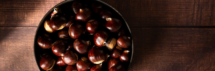 Close up view of chestnuts on table, space for text. Agricultural harvest concept. Healthy, seasonal food

