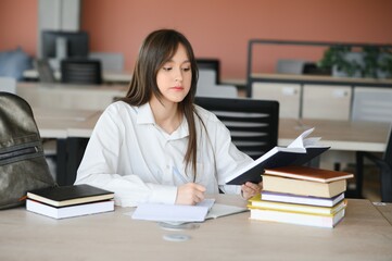 education and school concept - student girl studying and reading book at school.