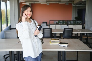 Portrait of a schoolgirl at school. She holds books in her hands. Education concept.