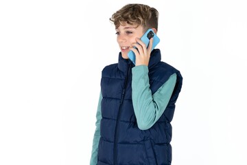 Happy joyful charming  Caucasian teen boy wearing vest jacket  speak phone smile good mood