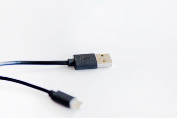 Black USB charging cable, compatible for many devices, isolated on white background.