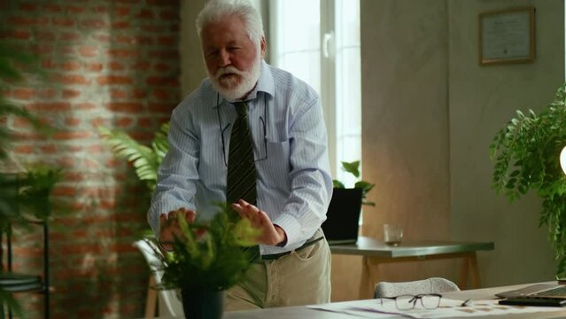 Elderly businessman practicing tai chi exercise in office
