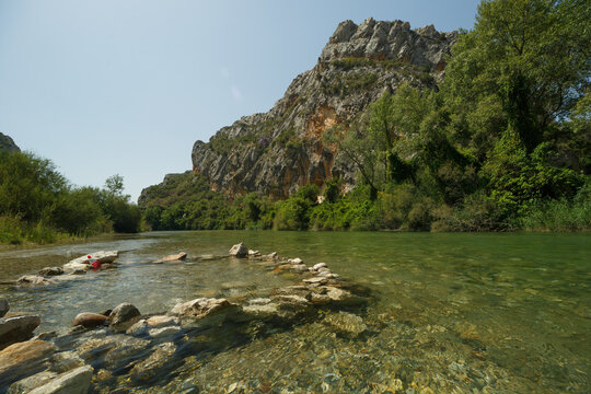 R&iacute;o de agua transparente delante de una presa con piedras en circulo dentro del agua 