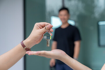 Real estate agent delivering keys house, Hands pass a house key as a symbol of real estate and...