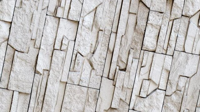 Wall, masonry of flat chipped stones beige split uneven convex, rotating, turning, close-up macro
