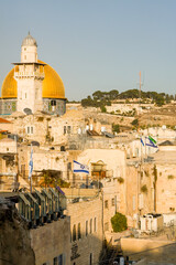 The Al-Aqsa mosque, Qibli Mosque or Qibli Chapel, المصلى القبلي, on the Temple Mount, old town of Jerusalem. Golden dome and ancient stone buildings. Israeli flag  seen in frame.