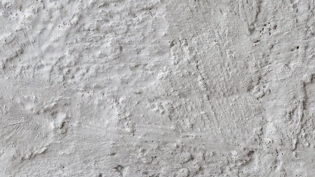 Rough plastered coarse light wall with divorces moving sideways, close-up macro
