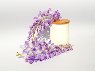 White bamboo cup with wisteria flowers on gradient white and gray background. Natural minimal concept. Creative spring idea. Wisteria decoration.