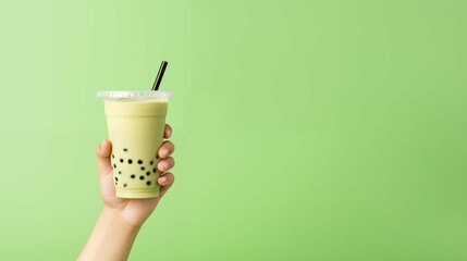 Hand holding matcha bubble milk tea over green background. Generative AI. - obrazy, fototapety, plakaty