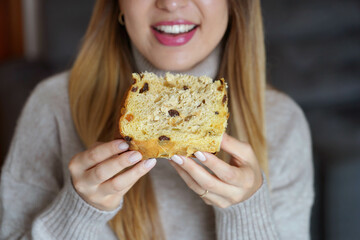 Unrecognizable girl holding a slice of Panettone traditional Christmas cake