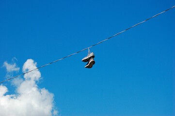 a pair of shoes hanging off the side of a telephone wire