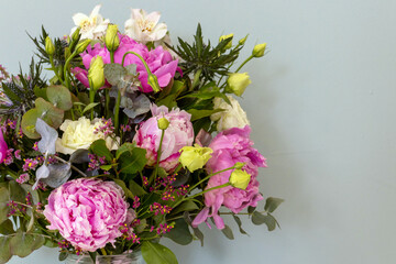 Bouquet of pink peony flowers in a vase on a gray background