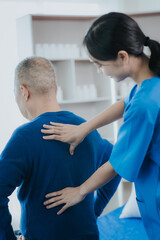 Obraz premium Asian female doctor or nurse exercising with elderly man at hospital