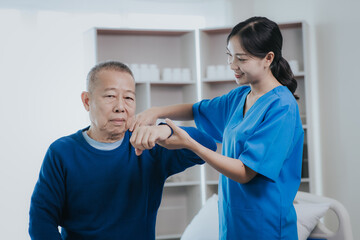 Obraz premium Asian female doctor or nurse exercising with elderly man at hospital