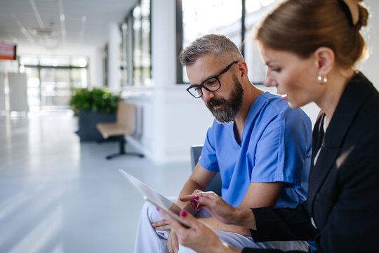 Pharmaceutical sales representative talking with doctor in medical building. Ambitious female sales representative presenting new medication. Woman business leader.