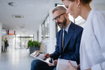 Pharmaceutical sales representative talking with female doctor in medical building. Hospital...