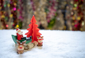 Sata sitting on white snow with group of gifts  in front of red origami Christmas tree waiting for...