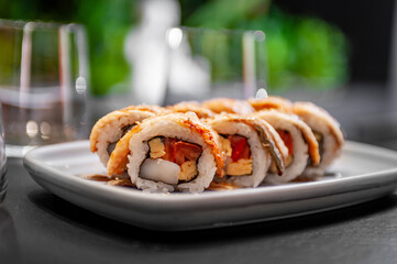 Sushi roll with eel, scallop, tomato and tamago on a plate