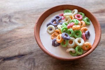 Fototapeta na wymiar Multicolored grain or corn rings. Breakfast with yogurt. Clay bowl. Balanced nutrition. Healthy Lifestyle. Colorful food. Nutritious snack.