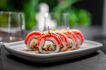 Sushi roll with tuna, cream cheese, cucumber and curry sauce on a plate
