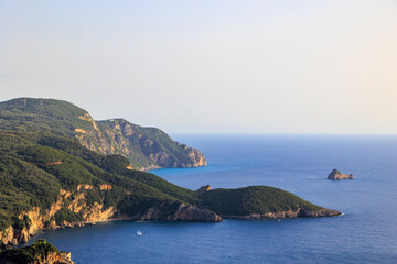 Fototapeta premium View in the evening under a blue sky over the bay and the sea at Paleokastrtitsa on the island of Corfu