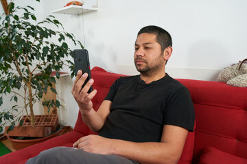 Man Sitting on Couch, Engaging in Video Chat