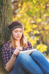 Obraz premium wireless technology, social networking, young adult, beautiful, beauty, digital tablet, female, nature, fall, caucasian, girl, cheerful, casual, student, computer, cute, blonde hair, defocused, e-read