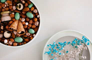 On a light background there is a round box filled with various nuts and dried fruits. Mothers Day. Valentine's Day. International Women's Day.