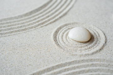 Fototapeta na wymiar White zen stone on sand round ripple