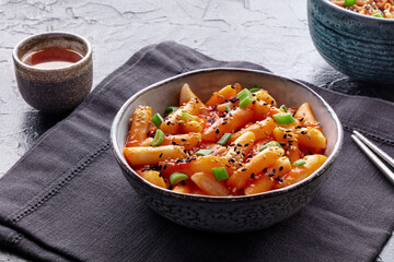 Tteokbokki or topokki, Korean street food, spicy rice cakes in red pepper gochujang sauce, a popular dish in a cafe