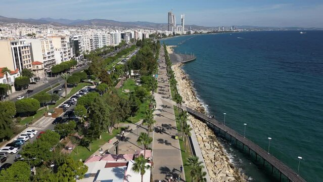 Drone flight over promenade towards skyline of Lemesos (Limassol), an important tourism and business center in Cyprus with a beautiful coastal location
