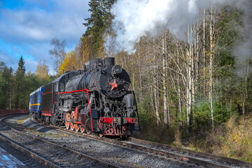 An old steam locomotive with a passenger train. Russia