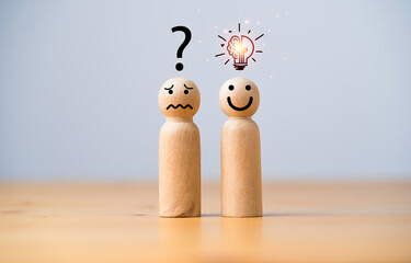 Smile wooden figure with glowing lightbulb and sad wooden figure with question mark for creative thinking idea can solving solution and innovation concept.