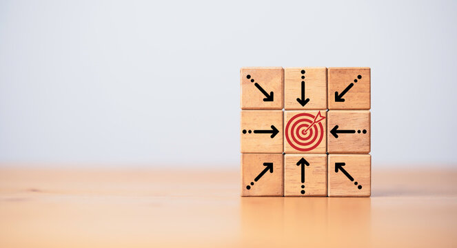 Center dartboard with arrow which print screen on wooden cube for focus on Business achievement goal and objective target concept.