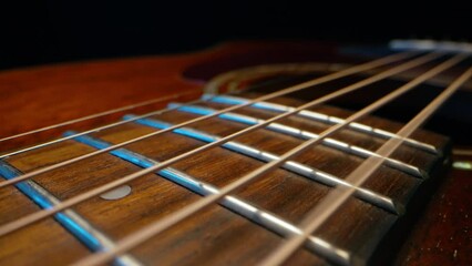 Acoustic guitar strings vibrating. Playing on classic music instrument. Sound waves, strumming chords, sound resonance. Super macro slider footage. - Powered by Adobe