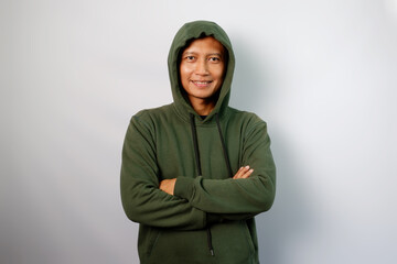 Adult Asian man wearing green hoodie standing confident with arms crossed showing happy expression