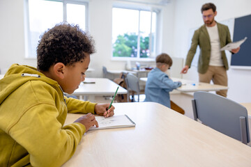 Kids at school sitting at the lesson and looking involved