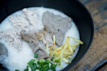 Congee, pork filling, boiled pork liver, and minced pork in a black bowl. Easy breakfast.