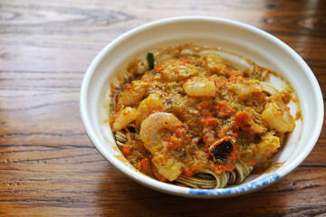 crab roe meat noodles on wooden table. Chinese seafood noodle dish