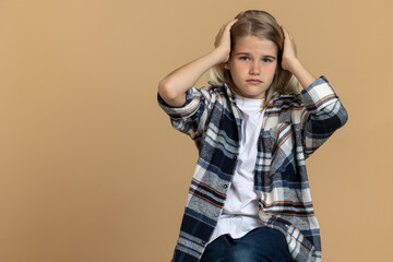 Teen girl in checkered shirt looking stressed and unhappy