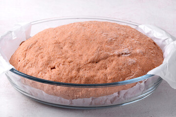 Proofing tomato sourdough bread in glass dish 