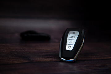 The car keys are black with metal inserts and automatic buttons on the side against a background of...